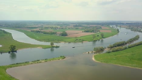 aerial drone view of the beautiful river with some boats passing by in the netherlands