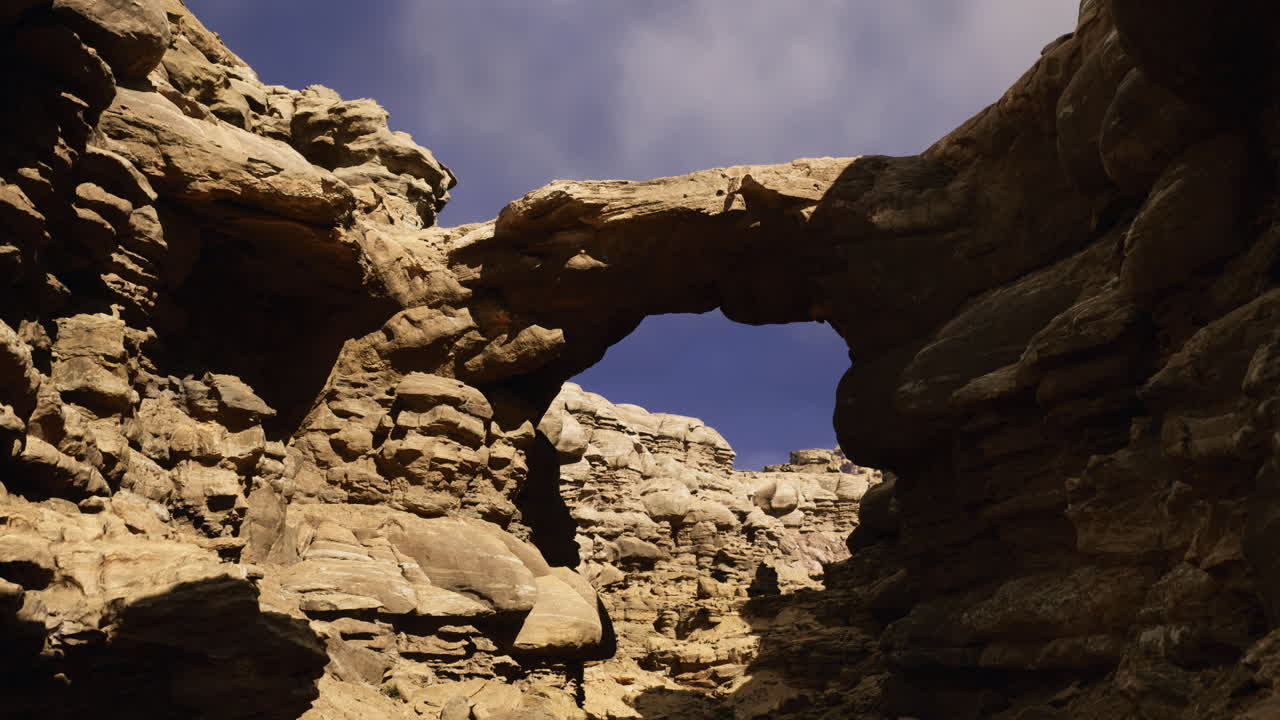 Natural rock formation in desert landscape under partly cloudy sky
