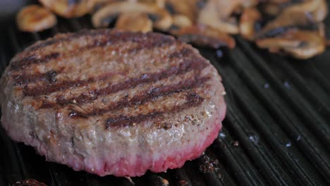 una hamburguesa frita a fuego medio en una sartén de hierro fundido