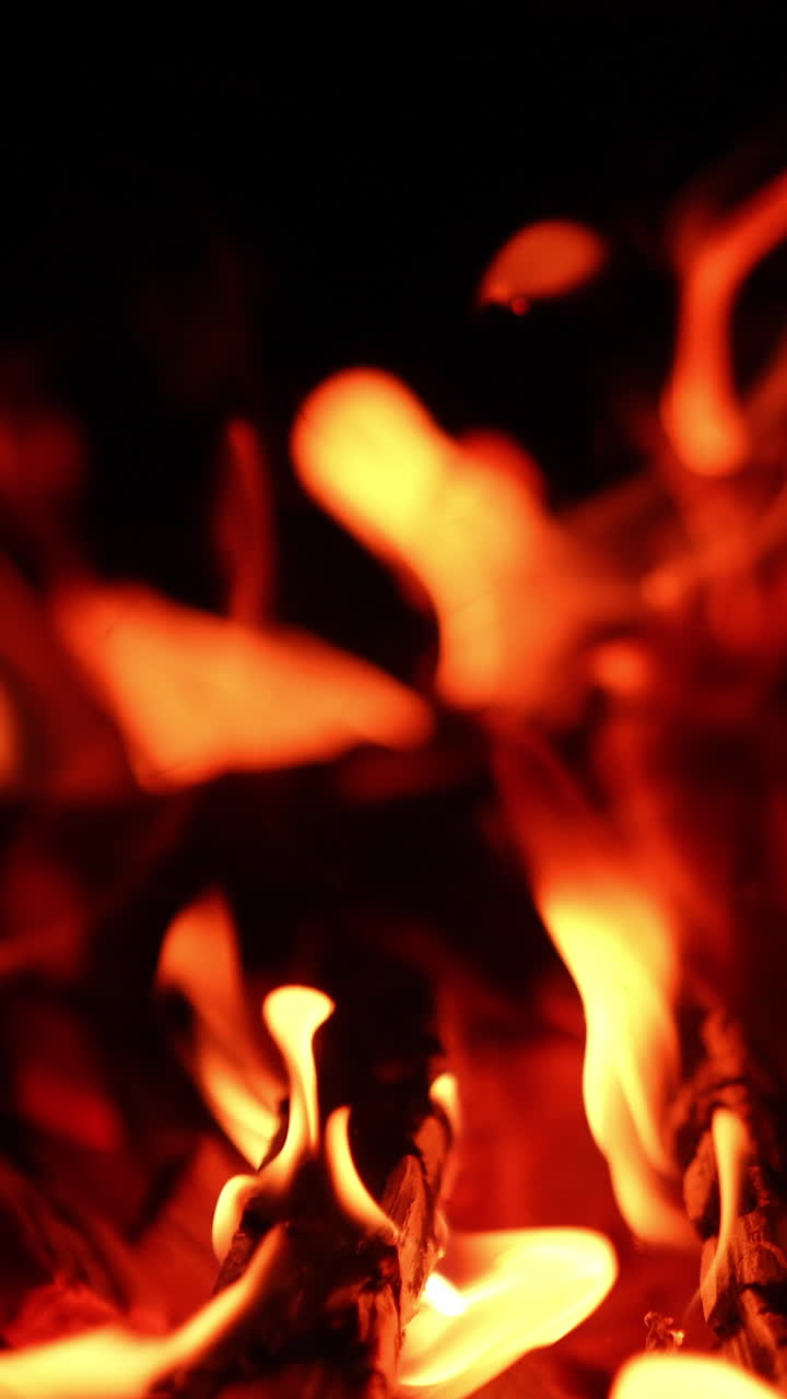 Fireplace close up flames glowing. Burning firewood warm place. Vertical video