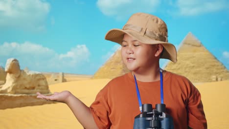 asian boy with a hat and binoculars smiling and pointing to side while traveling in giza pyramid. boy researcher examines something, travel tourism adventure concept, close up