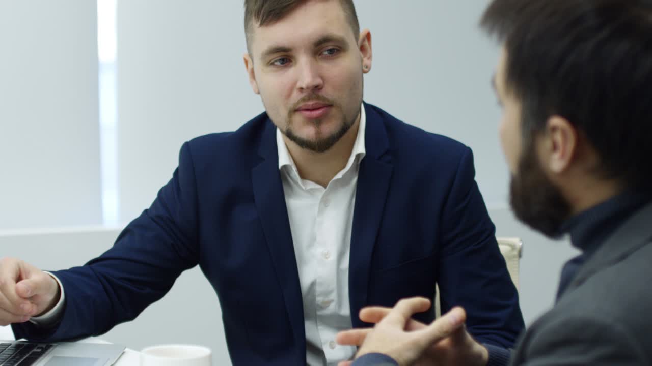 젊은 사업가 가 동료 와 함께 노트북 에서 프레젠테이션 을 논의 하고 있다