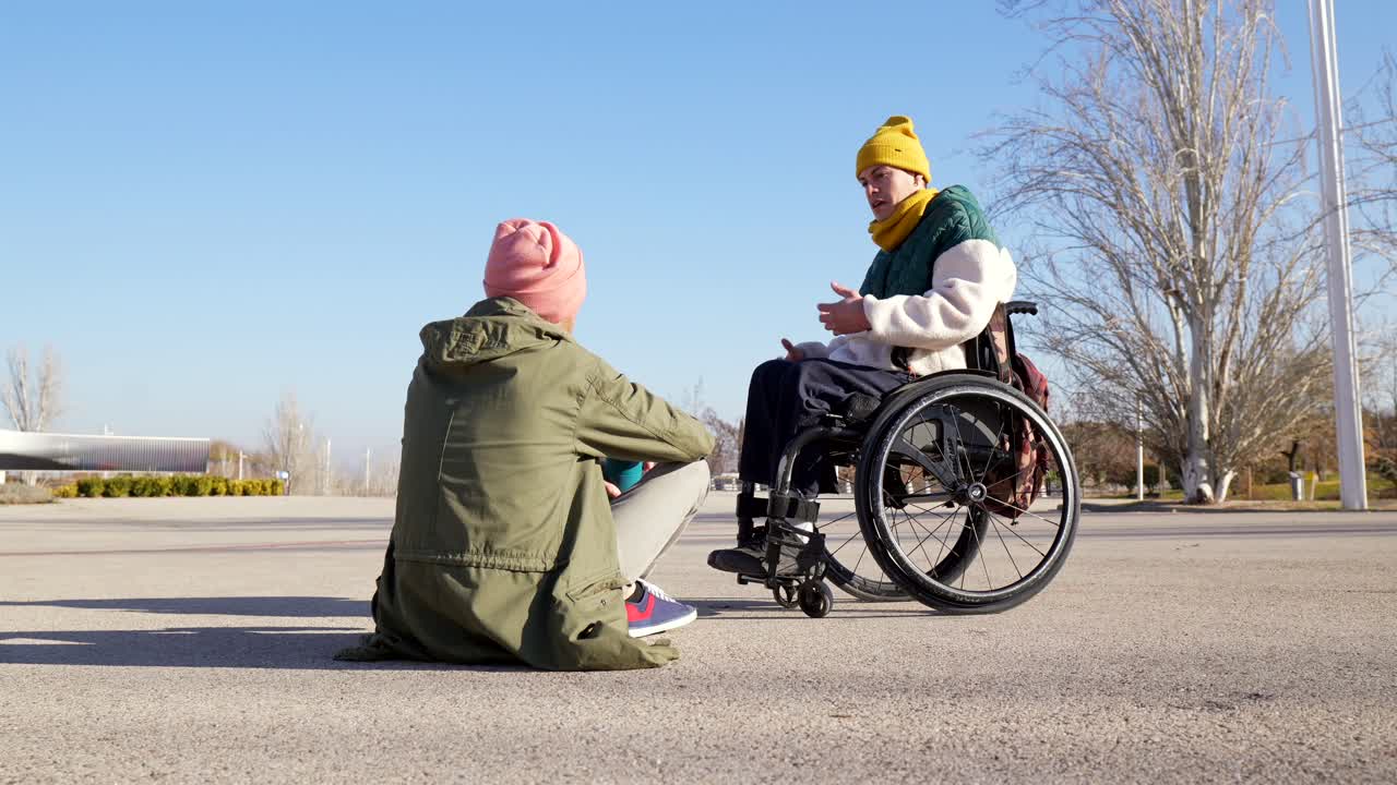 Two Friends Chatting Outdoors: One in a Wheelchair