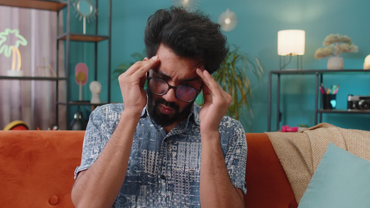 Displeased indian man rubbing temples to cure headache problem suffering from migraine stress