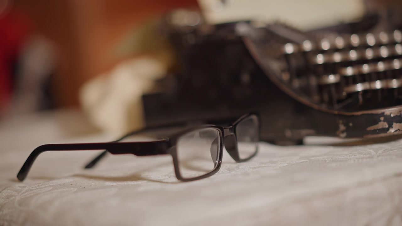 Vintage typewriter scene. Softfocused image of vintage typewriter with warm sepia hues. Gentle focus on aged metal typewriter placed on soft linen desk creating inviting storytelling ambiance