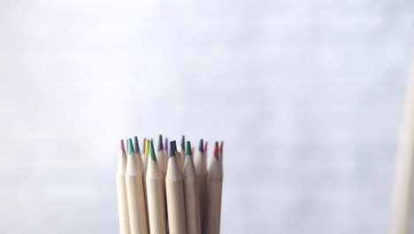 la mano del niño sosteniendo un lápiz de color sobre un montón de lápices