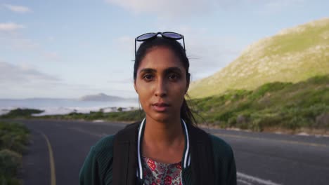 Portrait-of-african-american-woman-smiling-while-standing-on-the-road