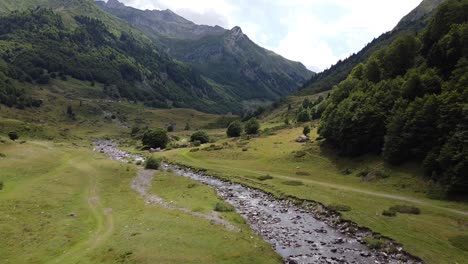 spanish pyrenees, spain - aerial drone view of green valley, flowing river and high mountains