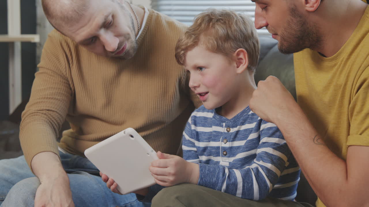 Male Partners and Their Son with Tablet Chatting