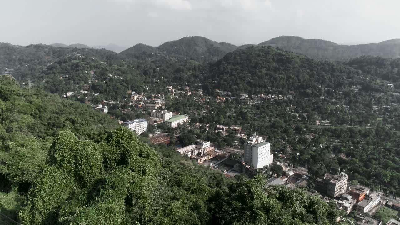 Ripresa aerea inclinata rivela la città circondata da grandi colline