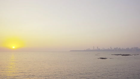 urban landscape of the coastal mumbai marine beach at dusk with skyline luxury buildings at the backdrop at sunset, wide angle shot, india
