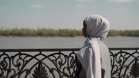 Thoughtful-Muslim-lady-looks-at-distance-on-embankment