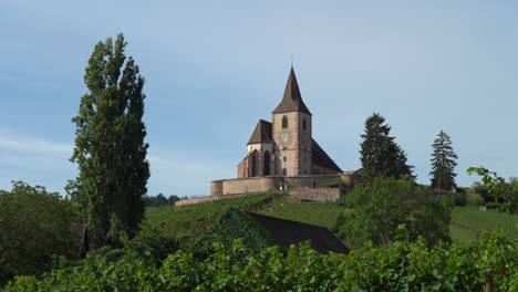 con vistas a la aldea de hunawihr, la iglesia del siglo xv o xvi de st jacques le majeur, rodeada de un cementerio fortificado, ha preservado un entorno virgen