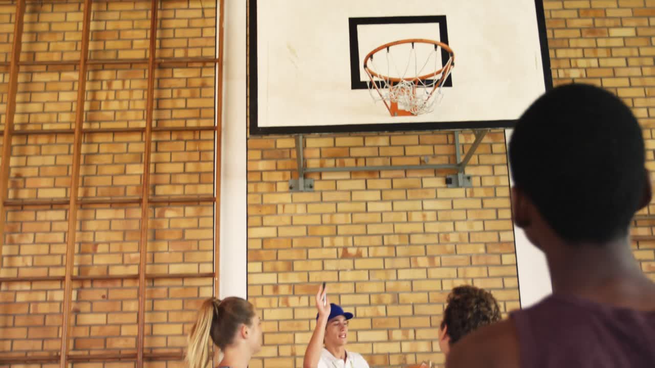 Squadra delle scuole superiori che gioca a basket