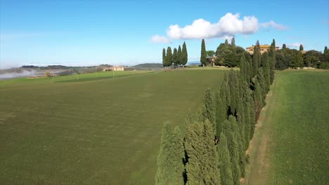 beautiful landscape scenery of tuscany in italy - cypress trees along white road - aerial view