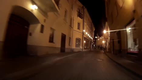 conduciendo de noche por la calle estrecha del casco antiguo de vilnius