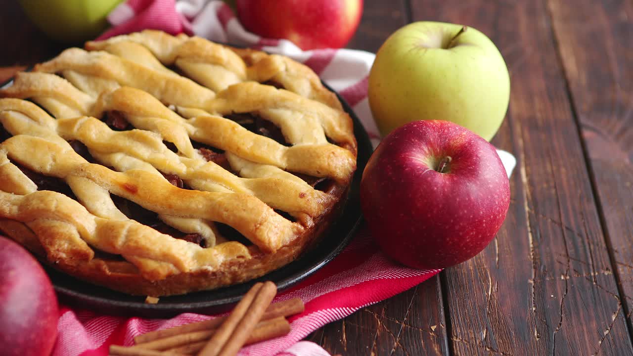 pastel de manzana casero con productos de panadería en la mesa de la cocina de madera oscura