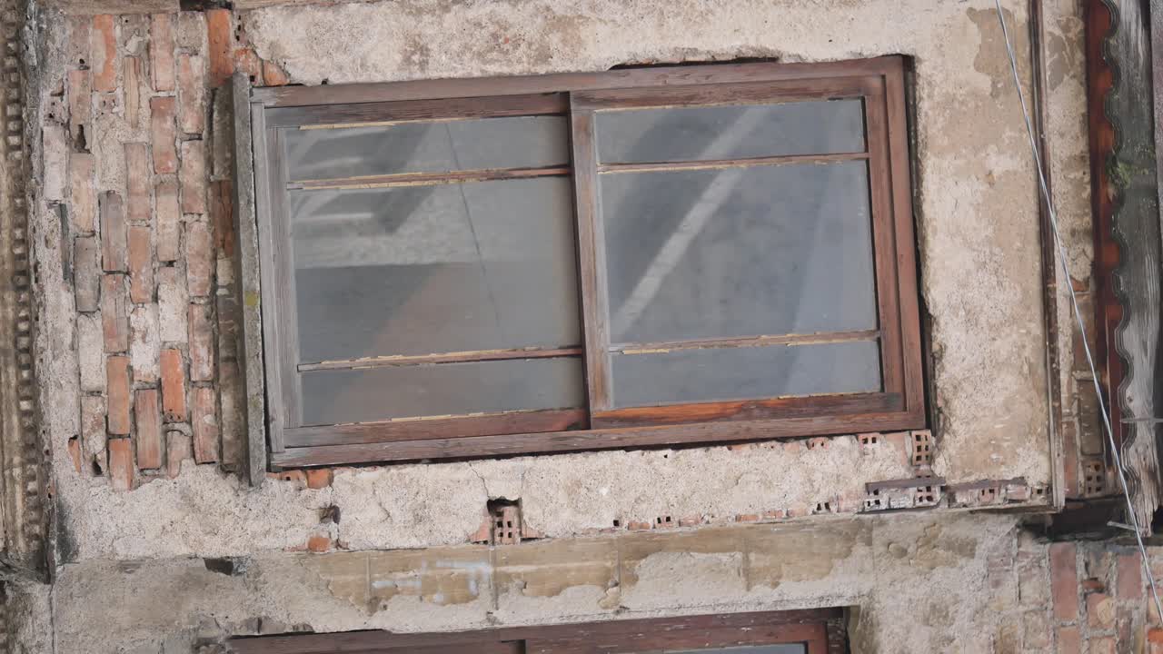 Old Weathered Window in a Damaged Brick and Plaster Wall