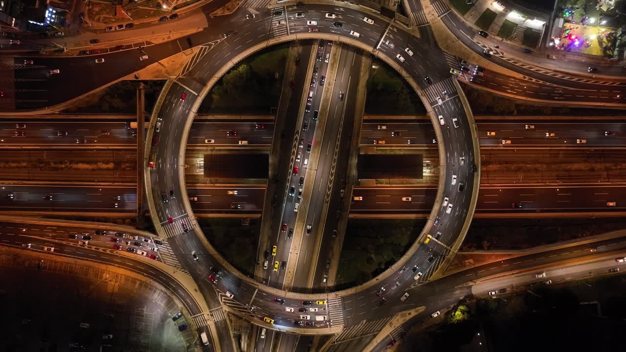 vuelo de drones sobre una autopista circular y varios niveles por la noche