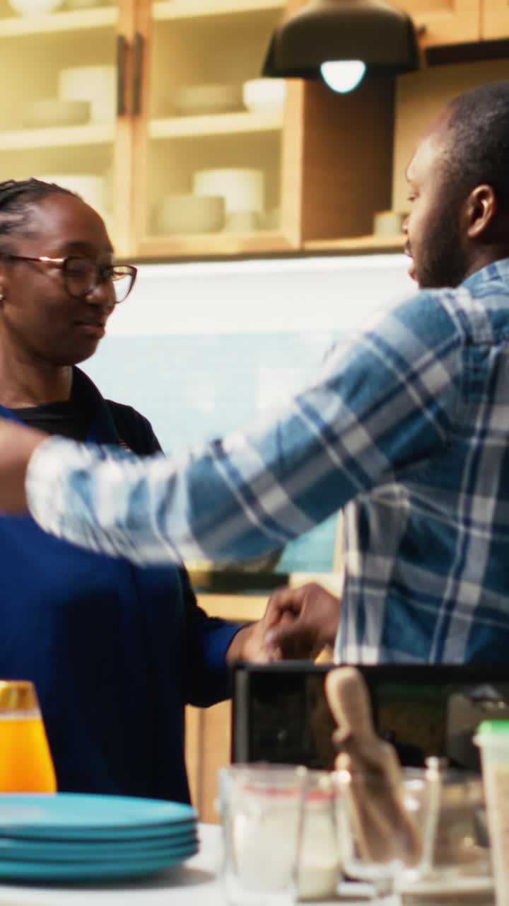Vertical Video Affectionate black couple sharing a cute waltz in the kitchen
