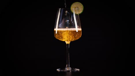 a cocktail glass with lime garnish