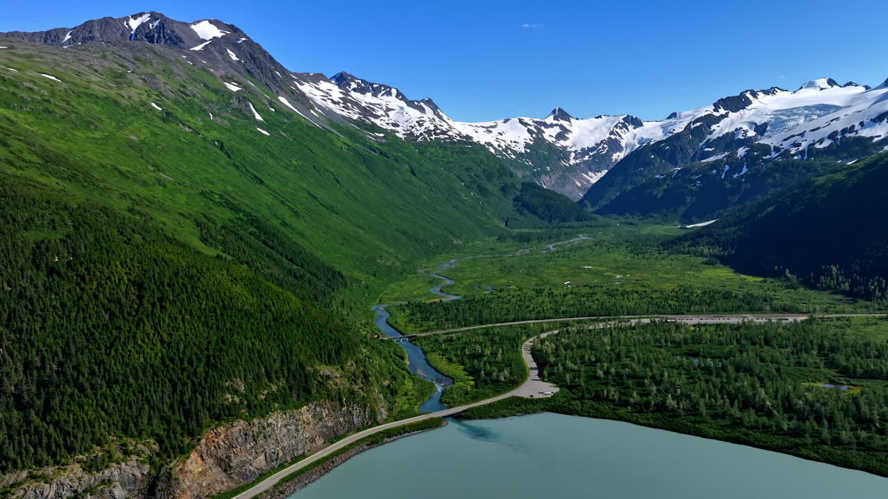 Alaska stunning natural beauty. Alaska vast green valleys and snowy mountains offer breathtaking beauty under clear skies