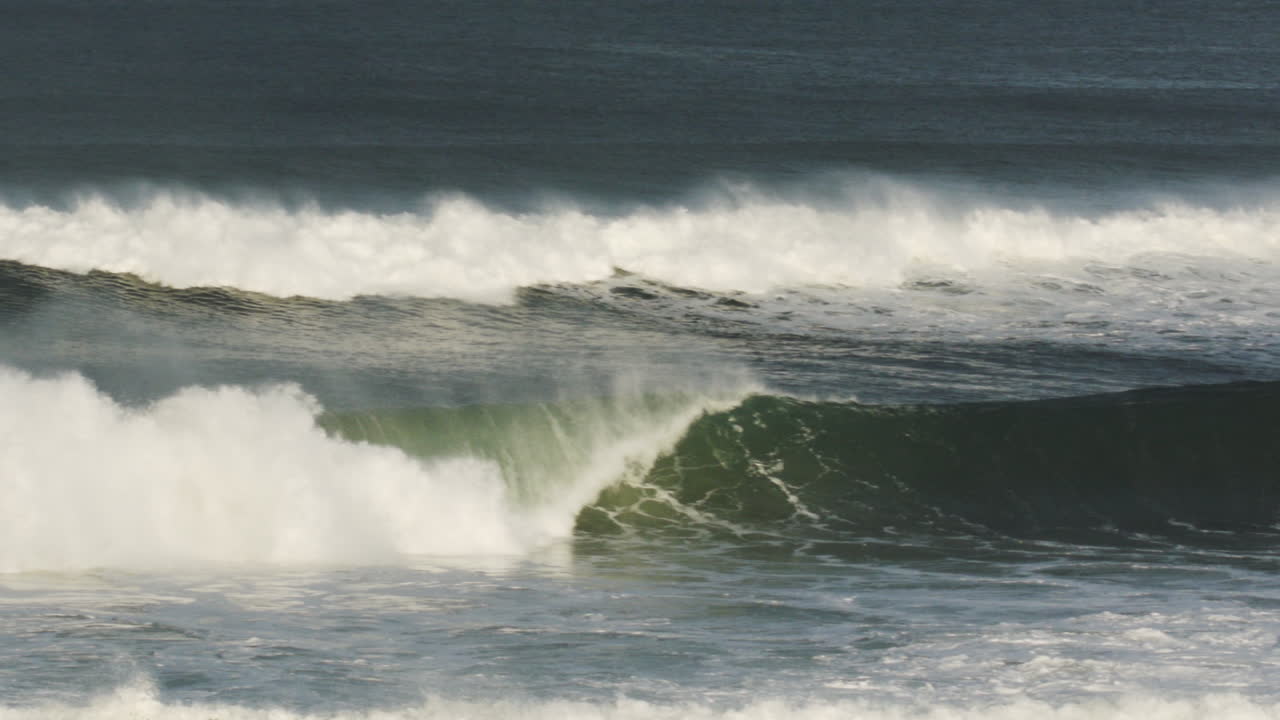 Low-angle curl shot of wave forming perfect tunnel at coast