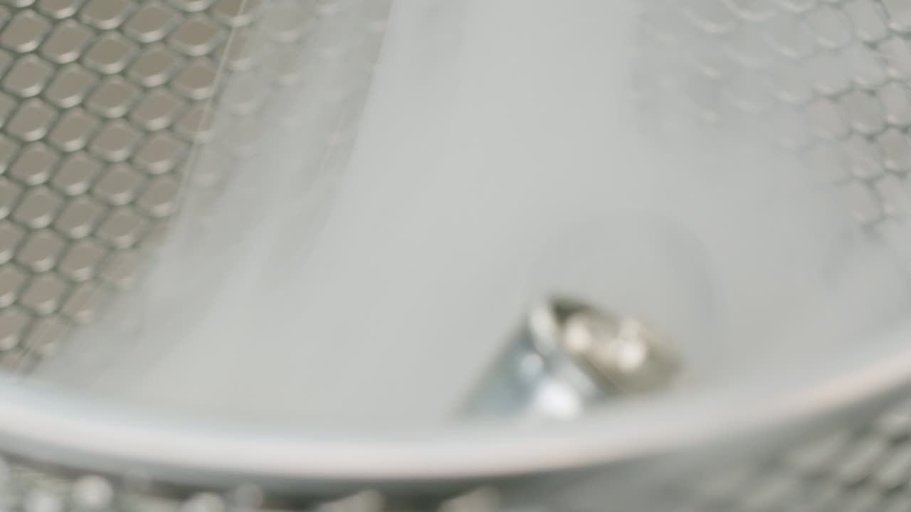 Silver batteries AA and AAA in wastebasket with smoke around close-up. Double-A battery is a standard size single cell cylindrical dry battery. Batteries are common in portable electronic devices. Environmental impacts of lithium-ion batteries concept. An AA battery is composed of a single electroch