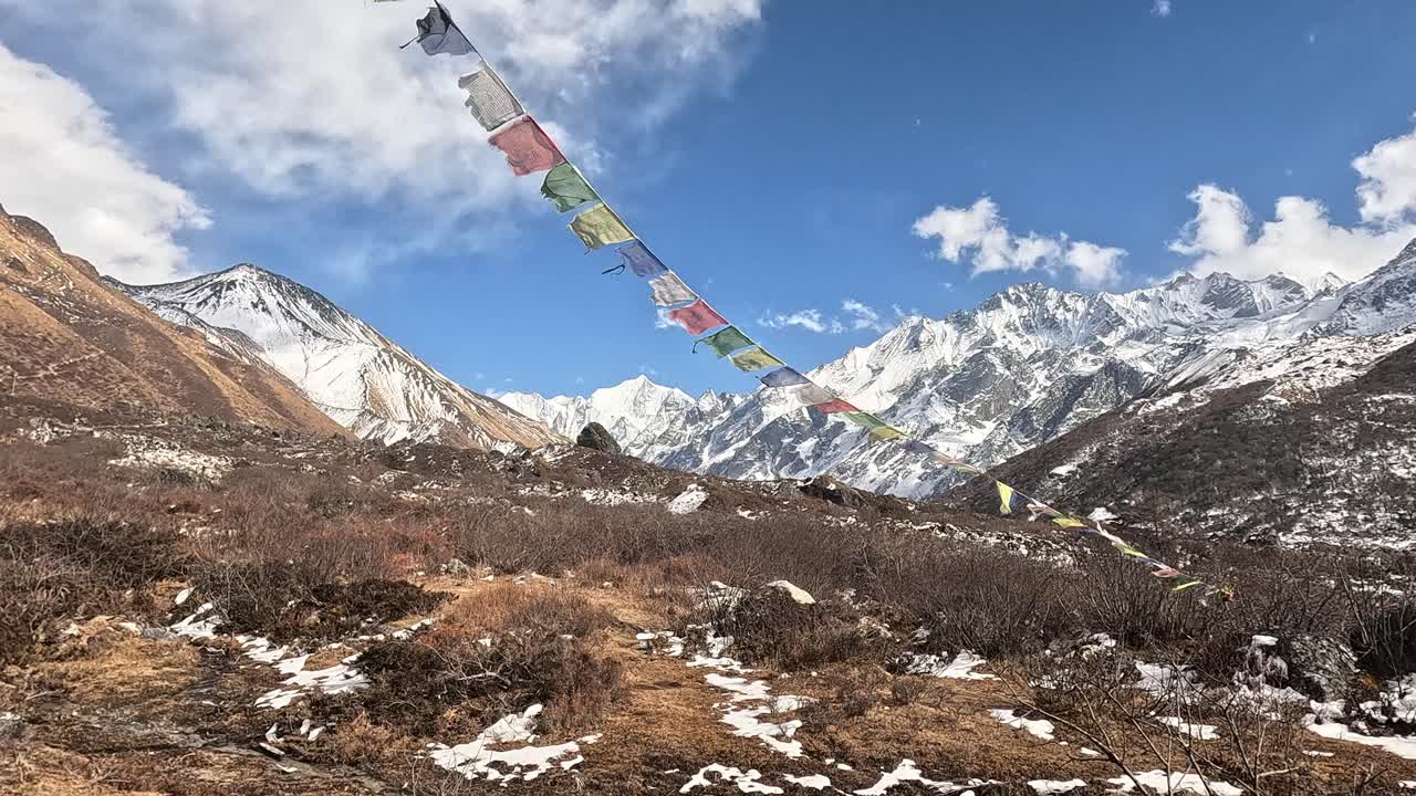 hermosas banderas de oración budista en el viento frente a la cumbre de gangchempo