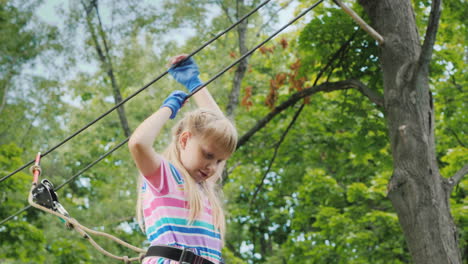 A-Brave-Girl-Moves-Along-The-Ropes-Between-The-Trees-Uses-A-Safety-Rope