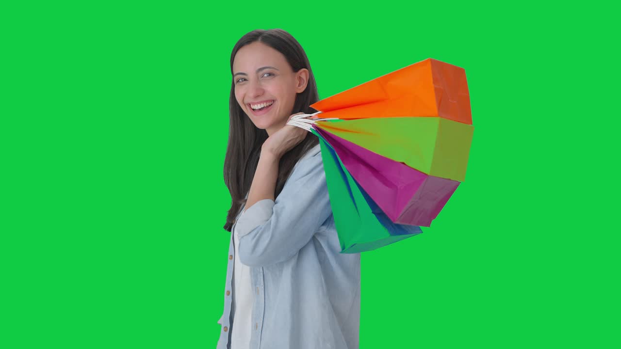 chica india feliz posando con bolsas de compras pantalla verde