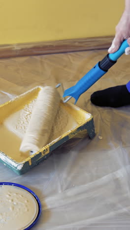 young worker painting in room. man painting wall during home decoration with roller brush