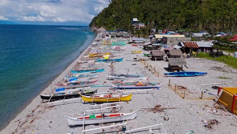 Luftaufnahmen-Von-Fischerbooten-Am-Ufer-Des-Mabua-Pebble-Beach,-Surigao,-Philippinen