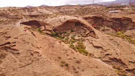 Several-tourists-visiting-Arco-de-Taja-desert-rock-formation-in-Tenerife,-Spain