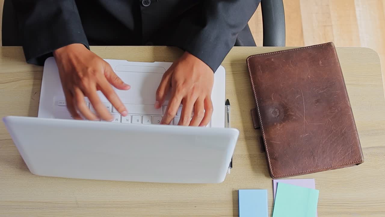 Top view of Professional man working on laptop at office desk with business accessories