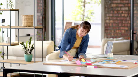 writing on sticky notes, woman brainstorming ideas in modern office workspace