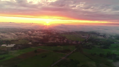 drone flying high above fog at sunset