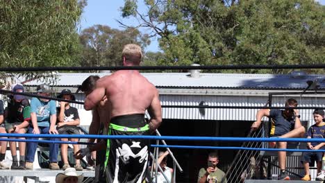 dos luchadores compiten en un ring al aire libre