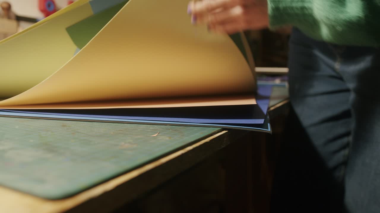 artista eligiendo entre hojas de papel de colores