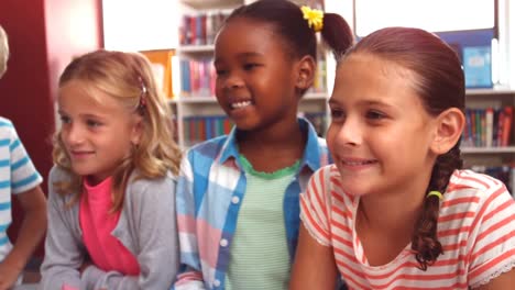 niños de la escuela sonriendo en la biblioteca