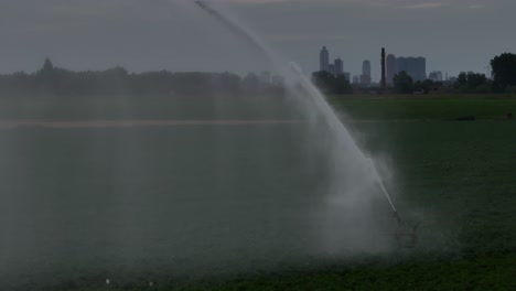 irrigation system in a field with city skyline in the background
