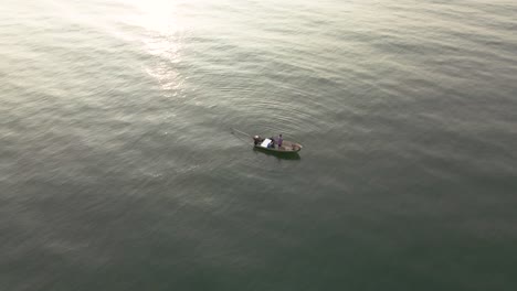 aerial drone shot of fisherman fishing in open water, thailand