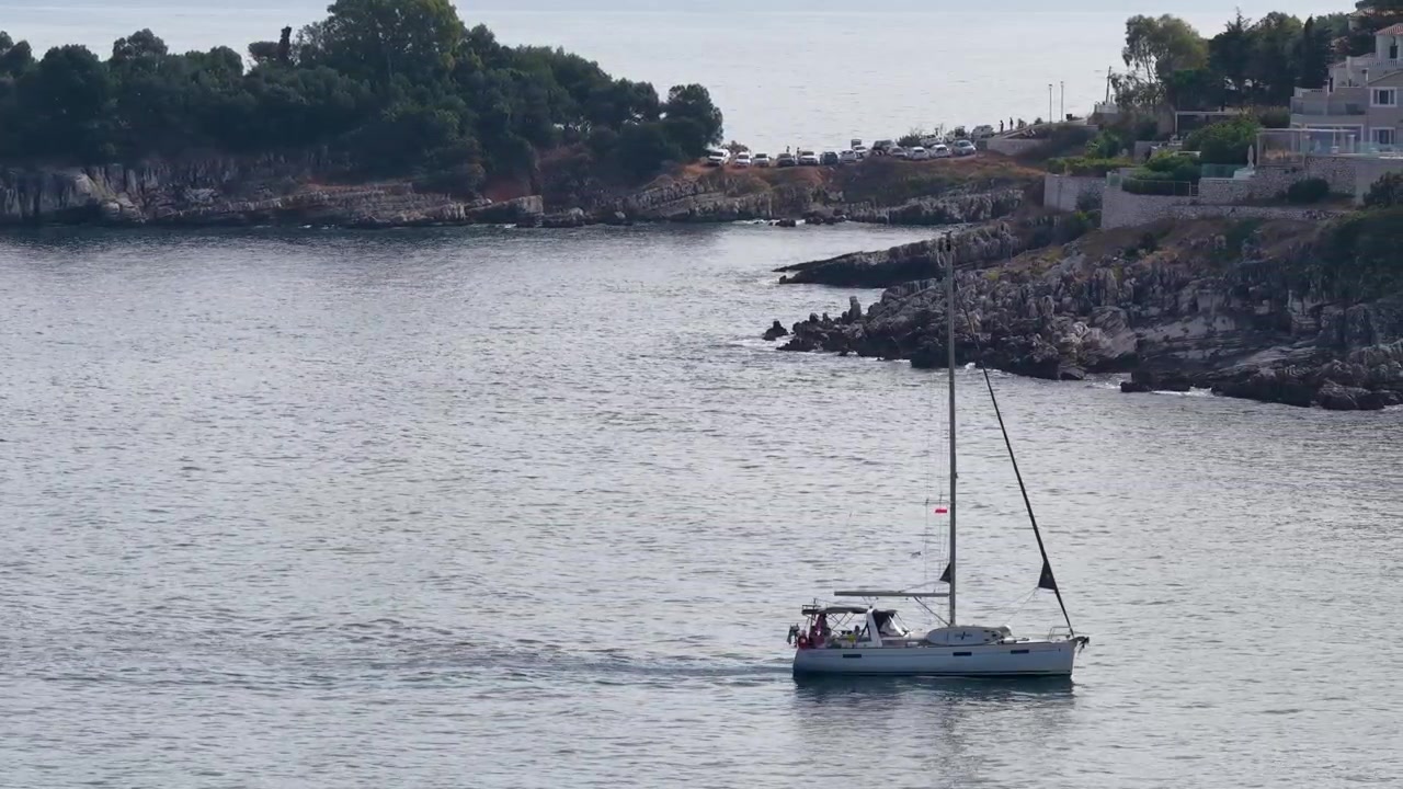 Barca a vela in crociera lungo la scenografica costa rocciosa di Kassiopi a Corfù, Grecia