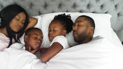 familia durmiendo juntos en el dormitorio 4k