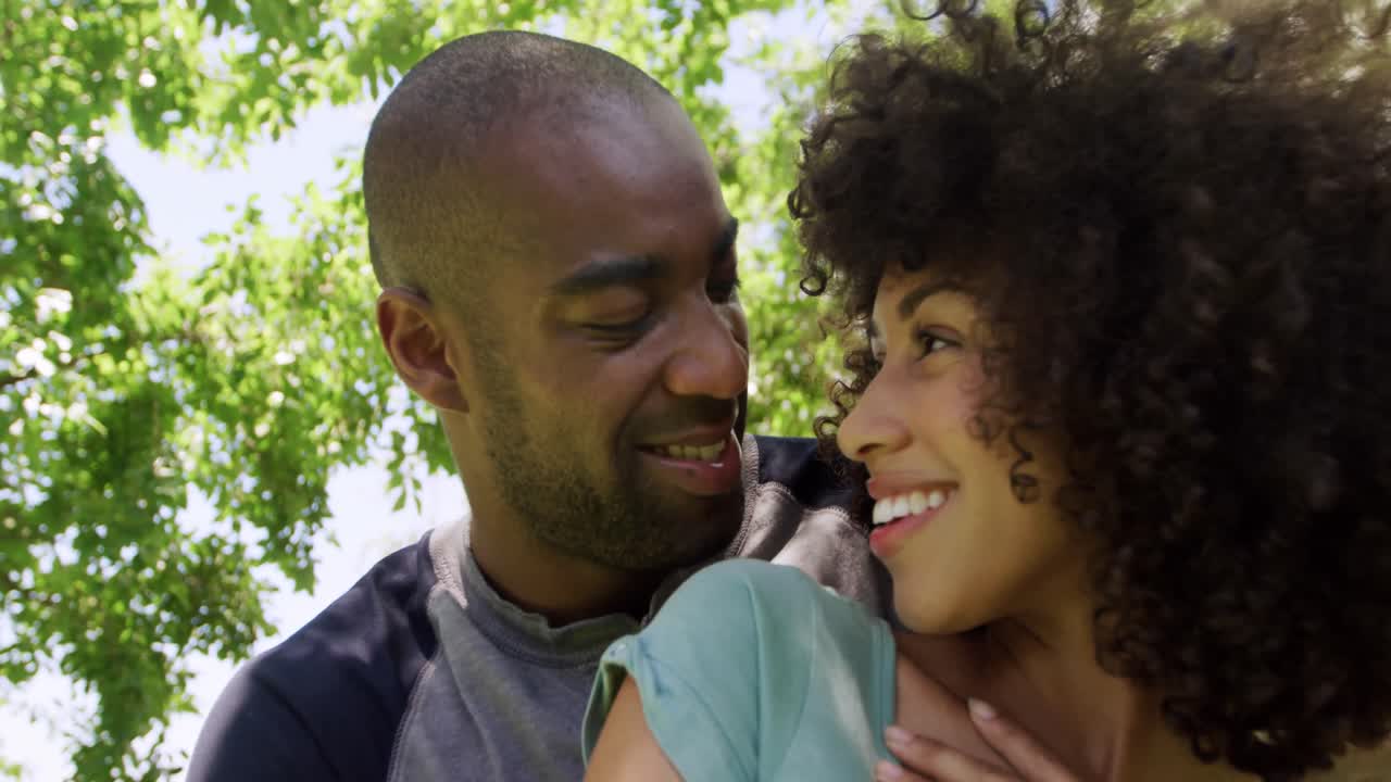 Happy mixed race couple enjoying in the garden during a sunny day