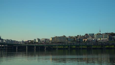 gangbyeonbuk-ro by the hangang river in seoul, south korea with famous namsan seoul tower in distance. wide