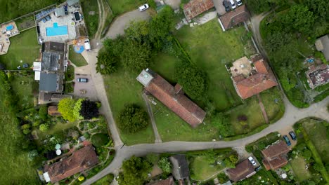 A-top-down-roll-shot-of-Womenswold,-centred-on-St-Margaret-of-Antioch-church