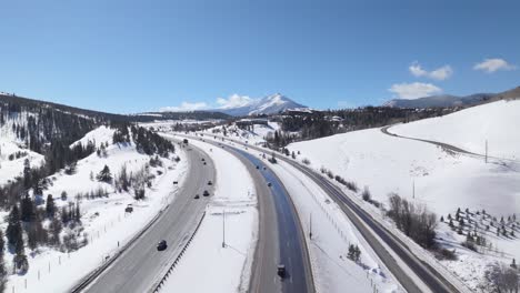 traffic on highway surrounded by snow, winter in colorado, sunny day