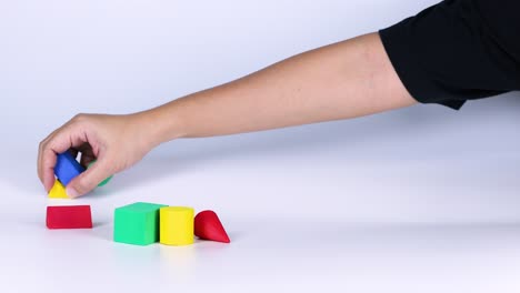 hands arranging colorful blocks on a surface