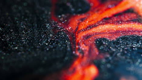 intense close-up of dark and bright red fluids blending together in a textured, abstract pattern
